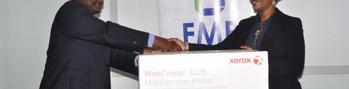 The Officer in Charge, Blantyre of the Fiscal Unit of the Malawi Police Service, receives one of the photocopier-printers from Sylvia Mataka, Head of Marketing & CSR, FMB